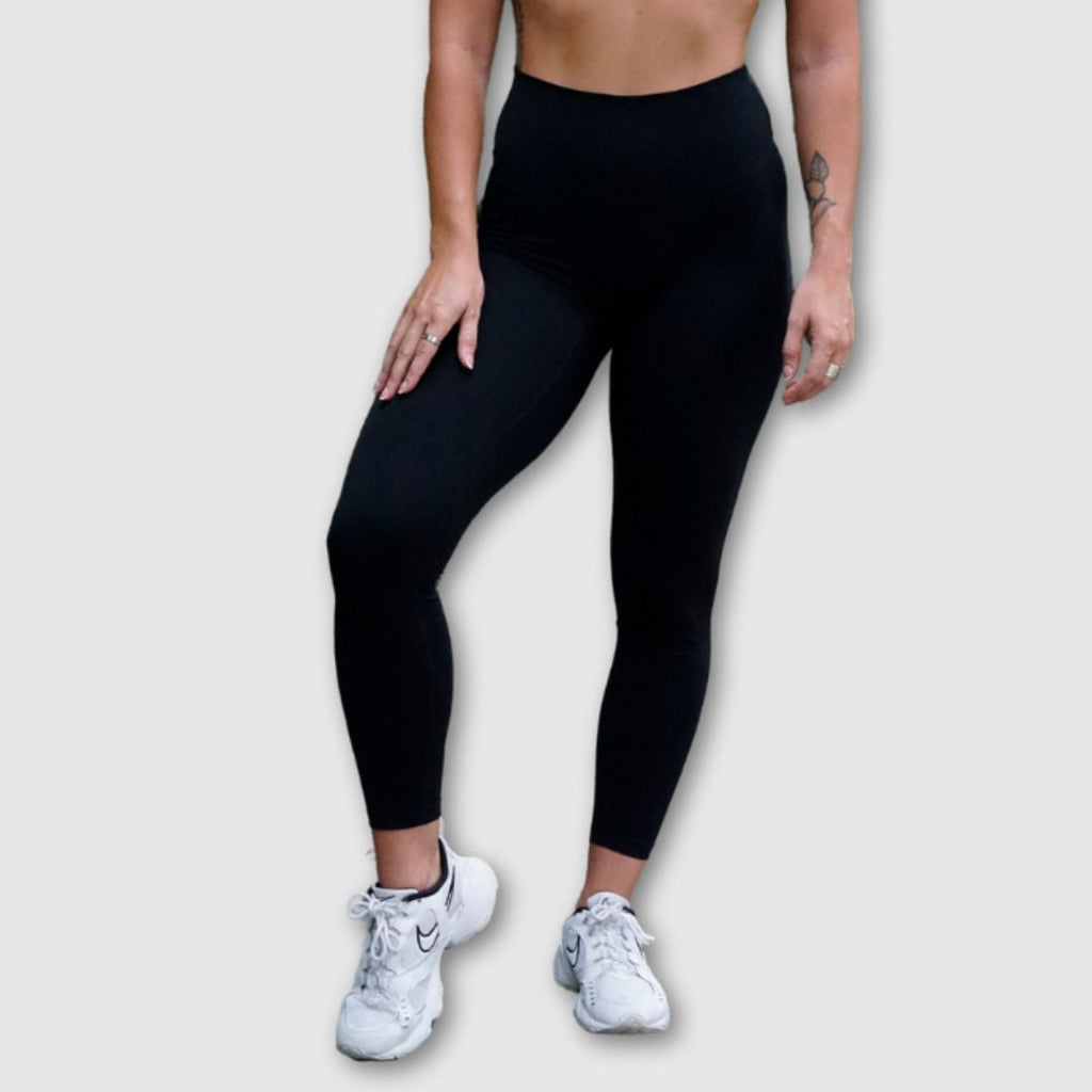Black Movement No Front Seam Leggings – Model squatting showing stretch and fit
