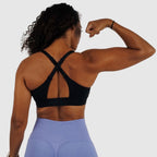 Back view of black sports bra, showing convertible straps crossed