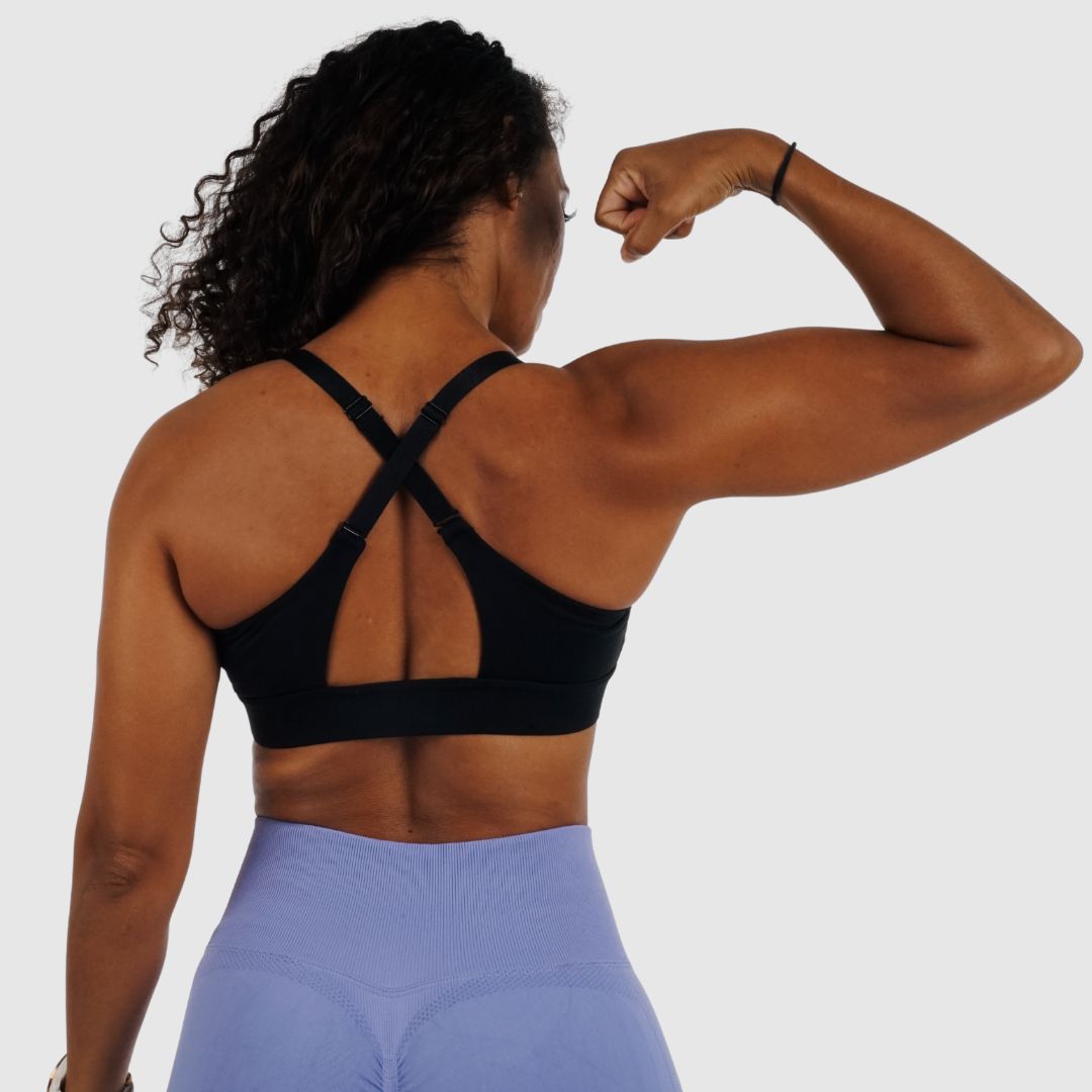 Back view of black sports bra, showing convertible straps crossed