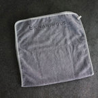 Detail of the premium 15 cm sewn-on logo on the dark grey workout towel.