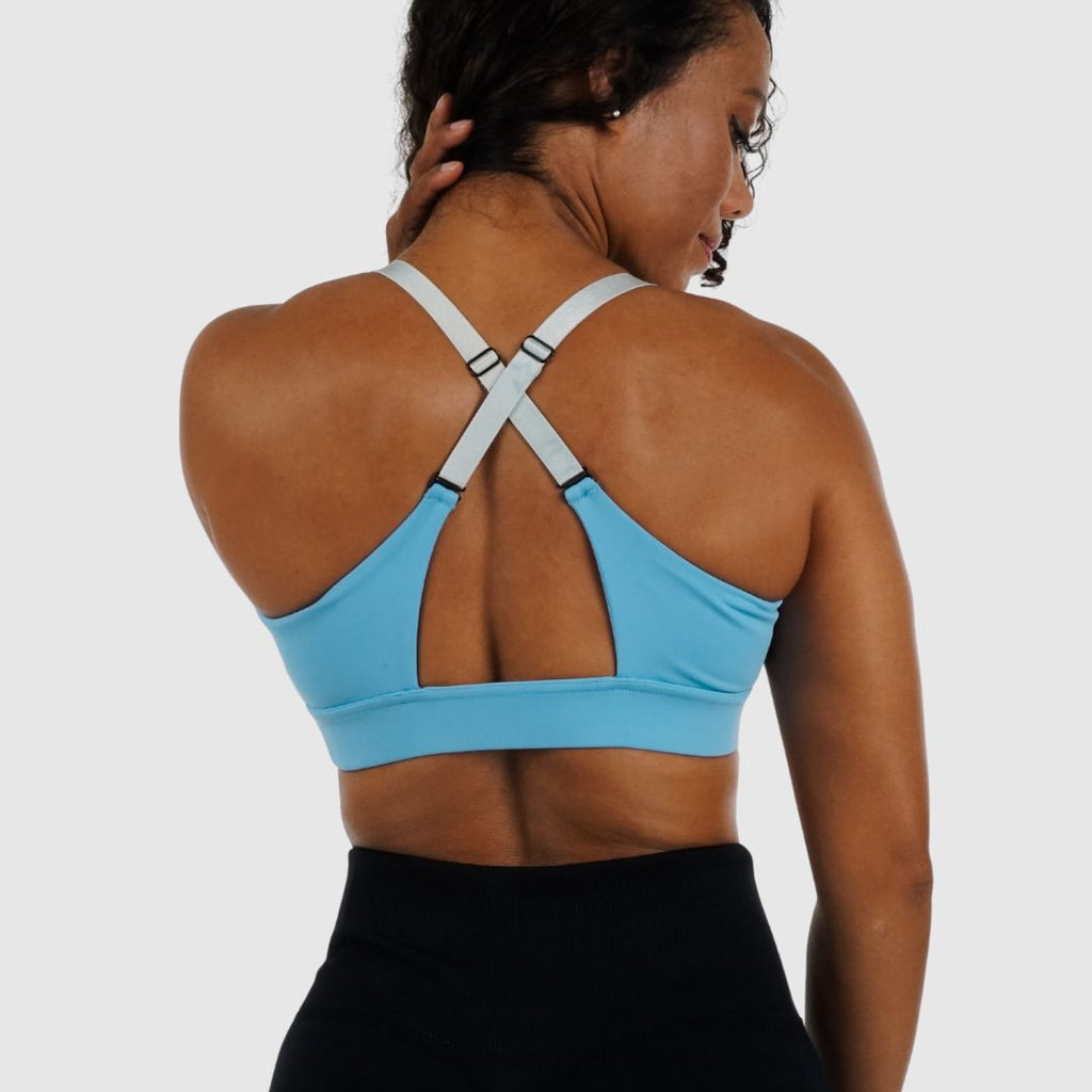 Light Blue bra with straps worn straight over shoulders.